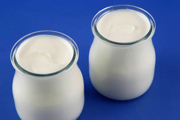 Tubs of natural yogurt, derived from cow's milk. — Stock Photo, Image