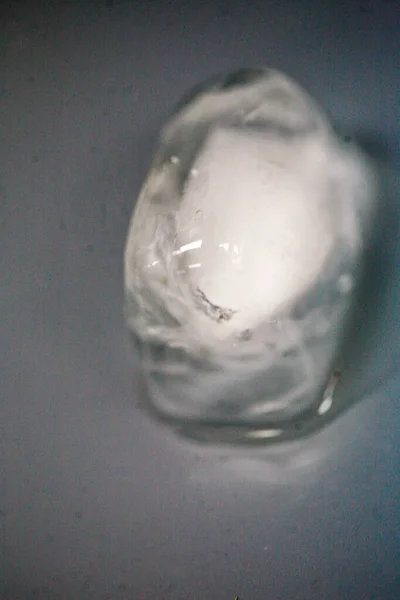 Un cubo de hielo se derrite sobre una mesa — Foto de Stock