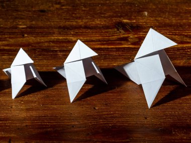 Beyaz kağıttan yapılmış papyon, parlak siyah bir arka plana yansıyor.