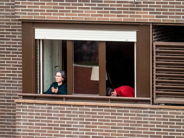 Madrid, İspanya - 29 Mart 2020: Covid-1 İspanya 'da alarm durumu. Madrid 'deki koronavirüs salgını her akşam saat 08: 00' de komşuları balkonlarına getirip bu epideyle savaşan doktorlar, hemşireler, polisler ve çalışanlara saygılarını sunar.