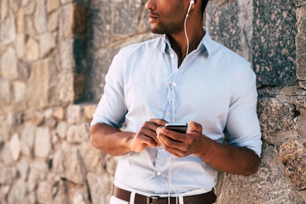 Uomo con cellulare in cuffia ascoltare musica — Foto Stock