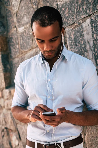 Homme avec mobile dans les écouteurs écouter de la musique — Photo