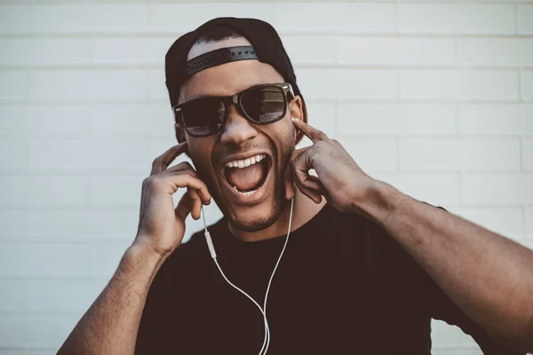 Homem africano bonito em boné e fones de ouvido — Fotografia de Stock