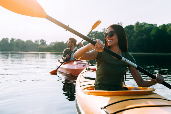 beautiful couple kayaking on river together