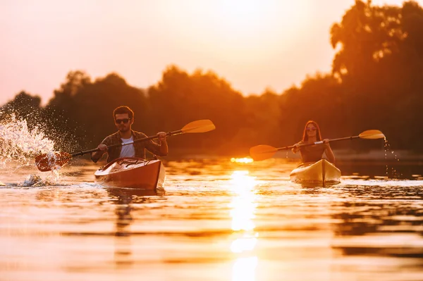 Vackra par paddlar på floden tillsammans — Stockfoto