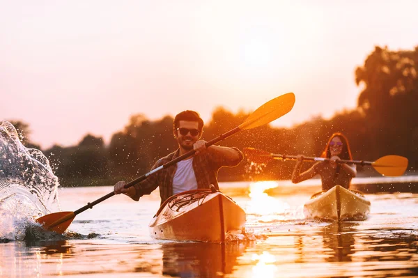 Vackra par paddlar på floden tillsammans — Stockfoto