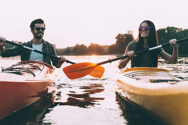 Vackra par paddlar på floden tillsammans — Stockfoto