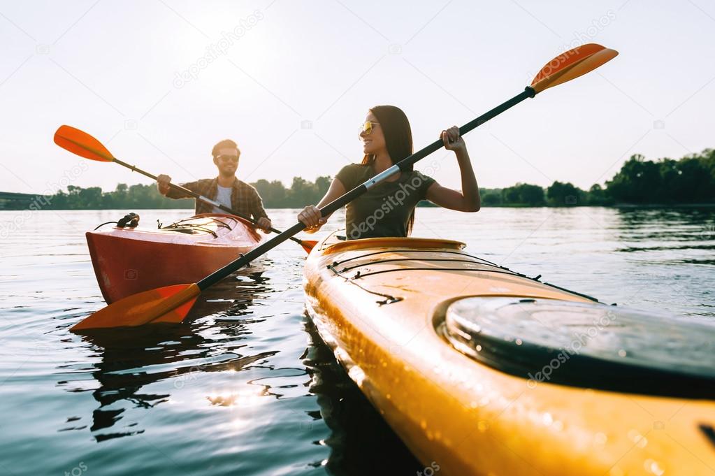 beautiful couple kayaking on river together