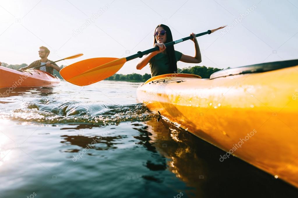 beautiful couple kayaking on river together