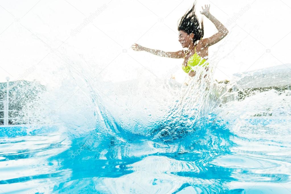 woman jumping into swimming pool 
