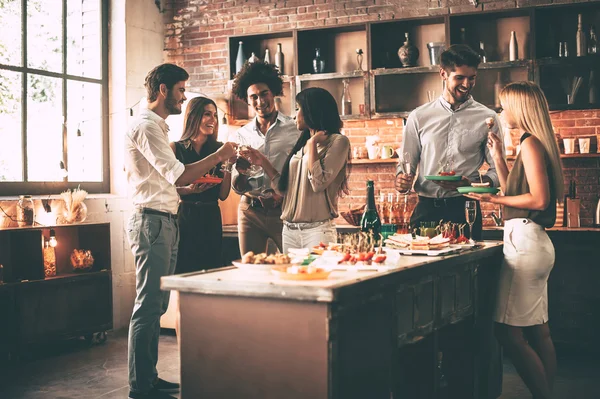 Friends enjoying meal at kitchen — Stock Photo, Image