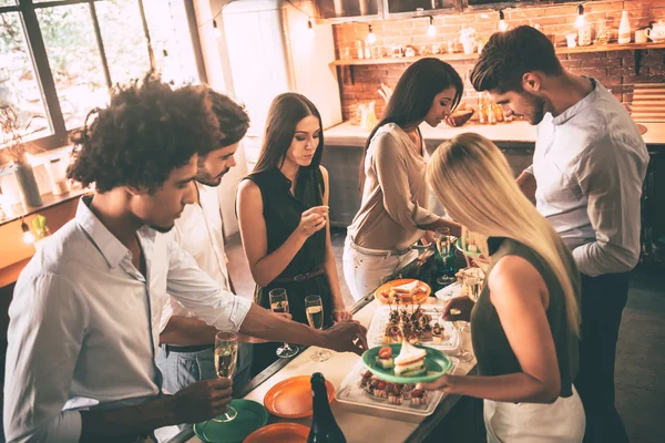 Friends cooking and talking at kitchen — ストック写真