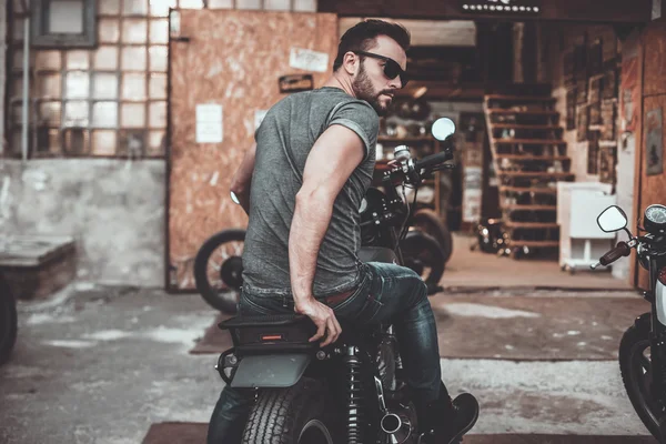 Hombre guapo sentado en su bicicleta — Foto de Stock