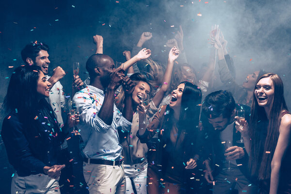 people dancing at party with confetti