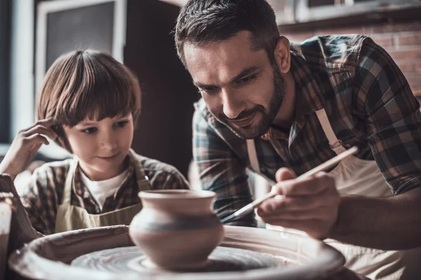 Батько і син роблять керамічний горщик — стокове фото