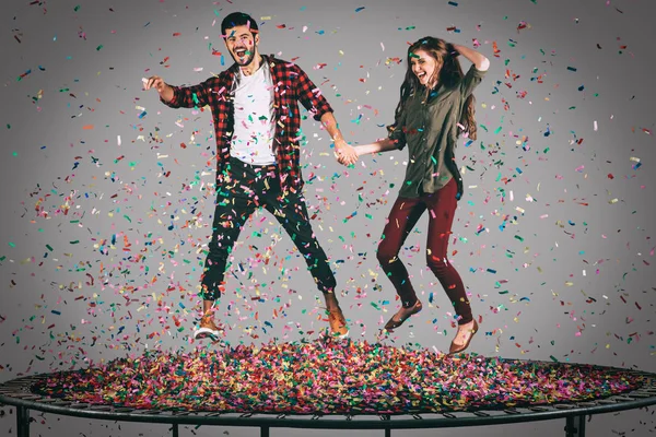 Cheerful couple jumping on trampoline — Stock Photo, Image