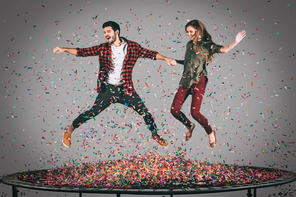 Glada par hoppar på studsmatta — Stockfoto