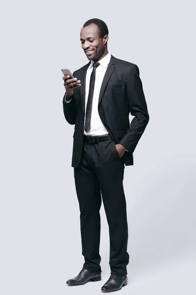 Man looking at mobile phone and smiling — Stock Photo, Image