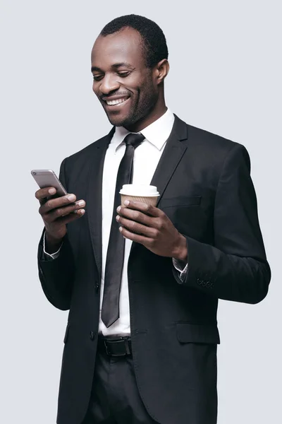 Homem olhando para o telefone celular e sorrindo — Fotografia de Stock