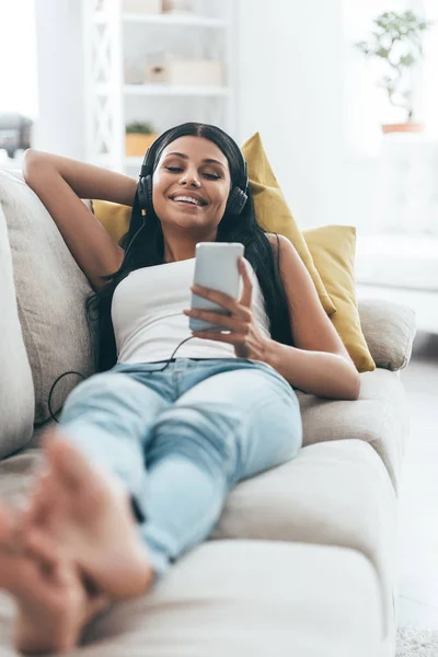 Mujer escuchando música y sonriendo —  Fotos de Stock