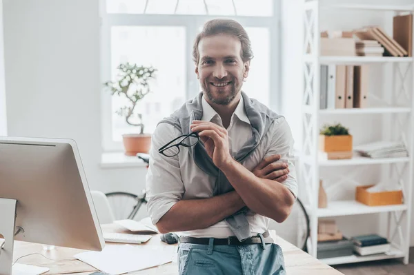 Hombre con ropa casual apoyado en el escritorio — Foto de Stock