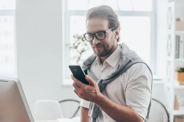 Homme souriant et regardant le téléphone — Photo