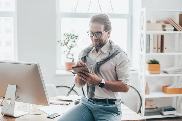 Hombre con ropa casual apoyado en el escritorio — Foto de Stock