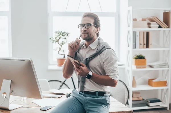 Hombre con ropa casual apoyado en el escritorio — Foto de Stock