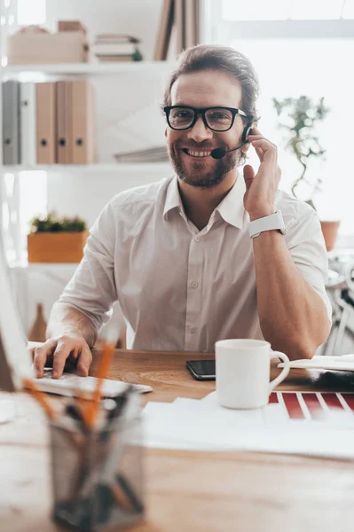 Homme en lunettes touchant casque — Photo