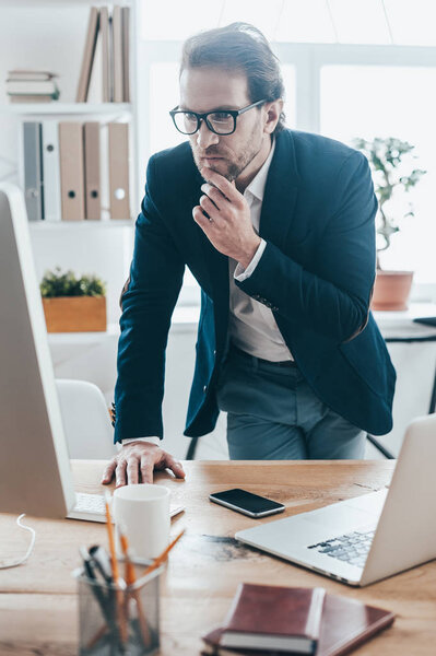 Man in eyeglasses looking at computer screen