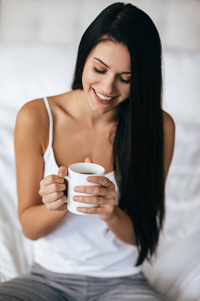 Attractive smiling woman holding cup 