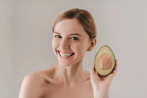 Beautiful woman holding avocado — Stock Photo, Image