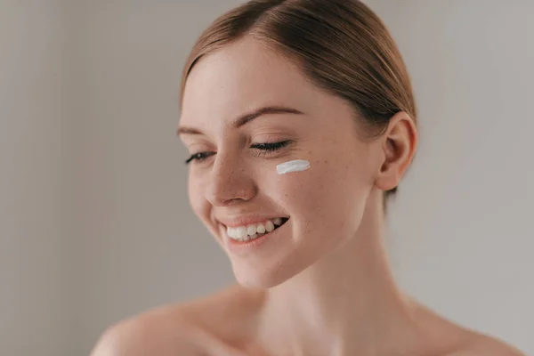 Beautiful woman with cream on face — Stock Photo, Image