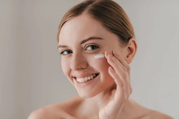 Donna crema di diffusione sul viso — Foto Stock