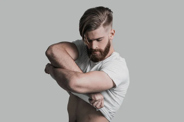 Homem com barba tirando sua camiseta — Fotografia de Stock