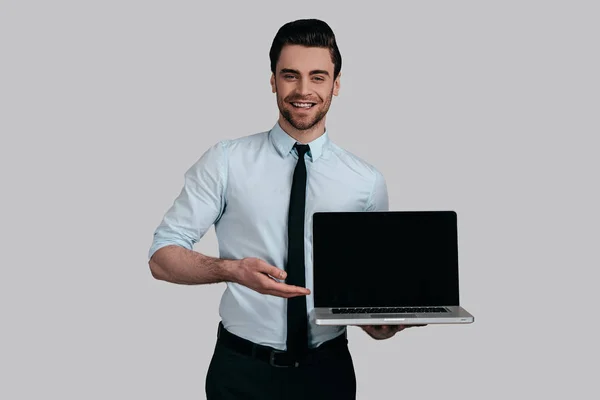 Uomo in possesso e mostrando laptop — Foto Stock