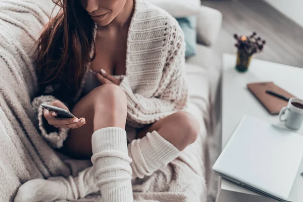 mobile ile kanepede oturan esmer kadın