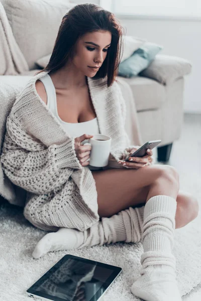 Mujer usando móvil y sosteniendo taza —  Fotos de Stock