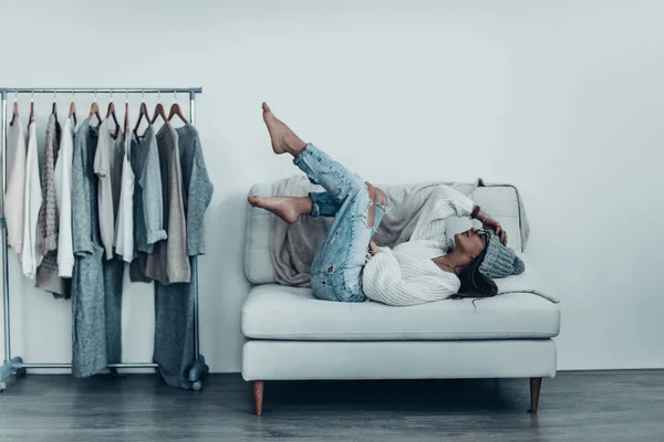 Lazy woman holding feet up — Stock Photo, Image