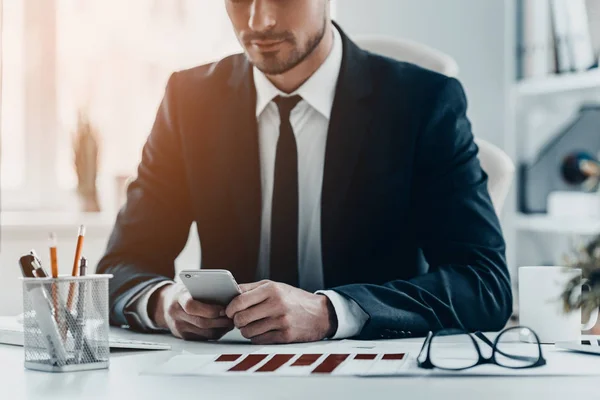 Homme d'affaires utilisant un téléphone portable à table — Photo