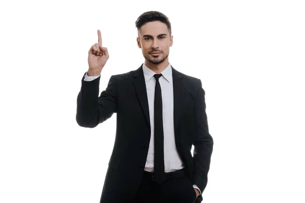 Businessman in black suit pointing finger up — Stock Photo, Image