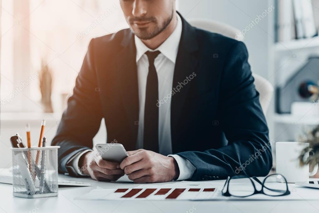 businessman using mobile phone at table