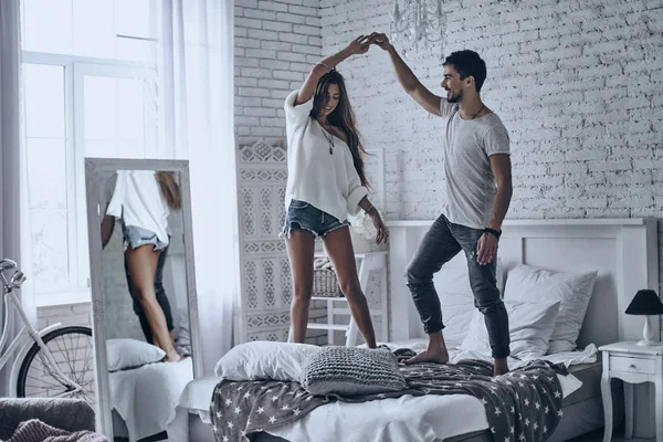 Hermosa pareja bailando en la cama —  Fotos de Stock