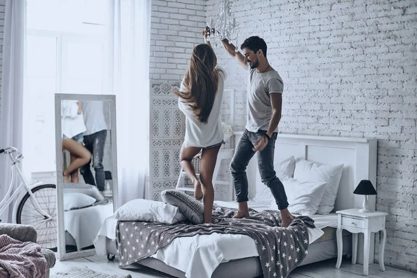 Hermosa pareja bailando en la cama — Foto de Stock