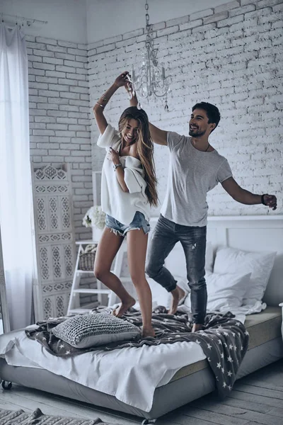 Hermosa pareja bailando en la cama — Foto de Stock