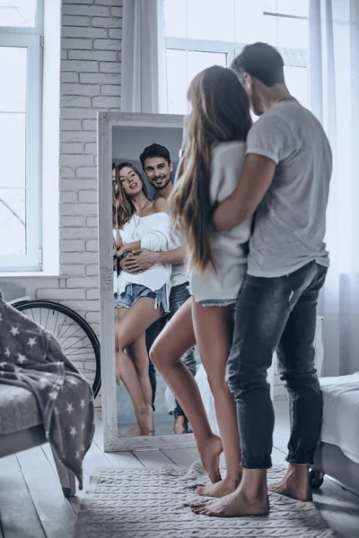 Encantadora pareja de pie en el dormitorio — Foto de Stock