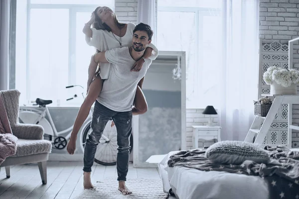 Mannen ger till flickvän piggyback ride — Stockfoto