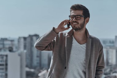 Genç adam cep telefonuyla konuşuyor.