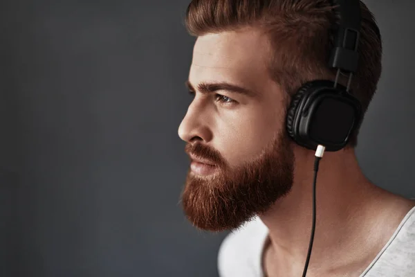 Handsome bearded man listening music — Stock Photo, Image