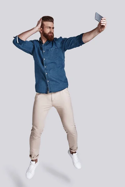 Man jumping and taking selfie — Stock Photo, Image